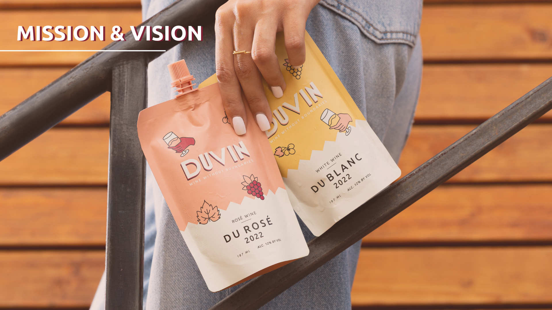 Two wine pouches labeled 'Duvin' held by a person against a wooden background.